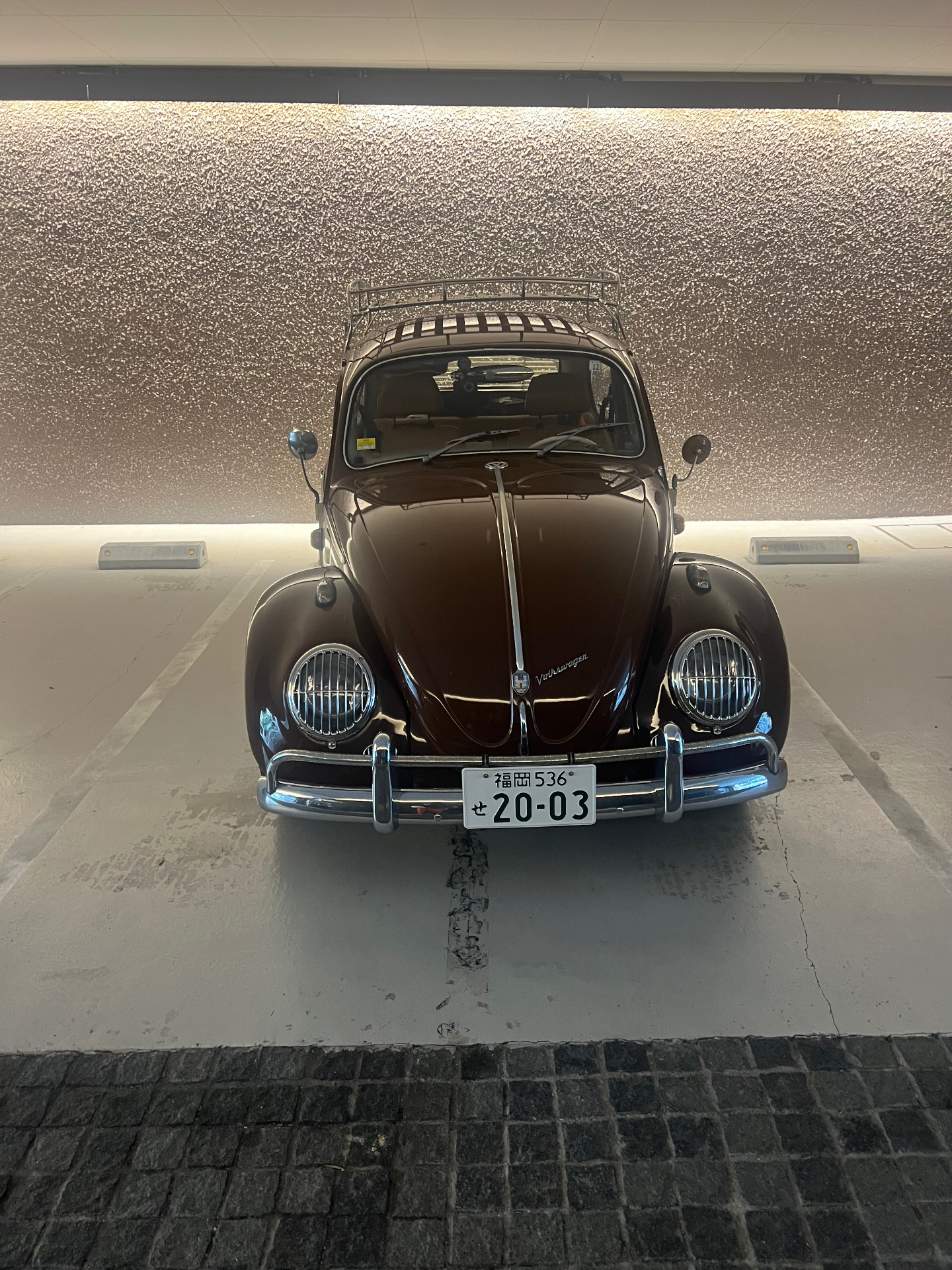 Klassischer brauner VW Käfer mit Fukuoka-Kennzeichen in einer Tiefgarage