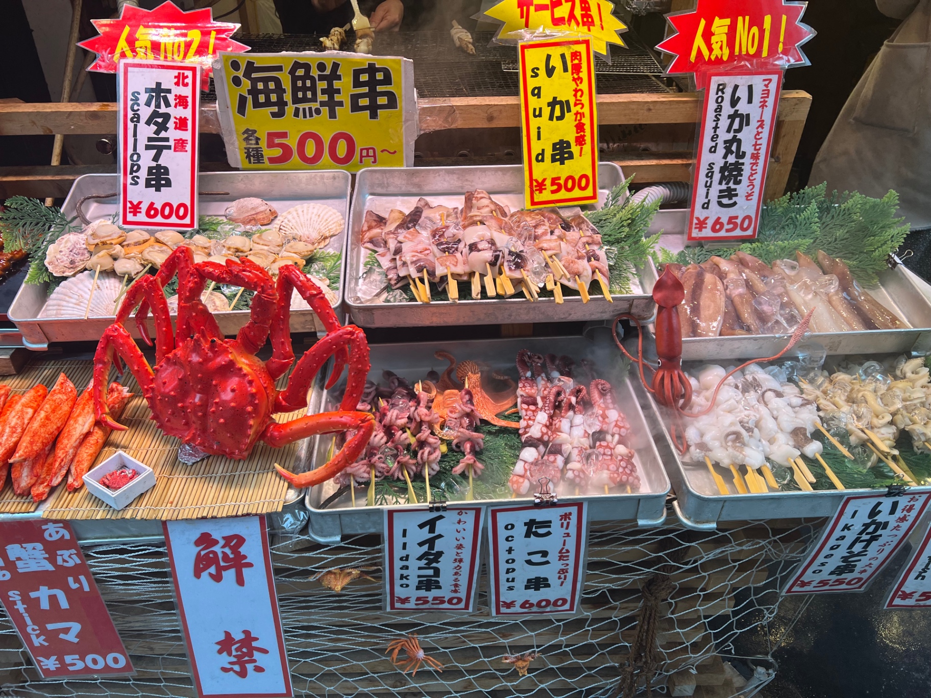 Marktstand mit Meeresfrüchte-Spießen: Jakobsmuscheln, Tintenfisch, Oktopus und Krabbe